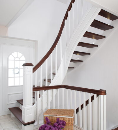 Wangentreppe beidseitig eingestemmt; Stufen Holzart Akazie; Wangen und Stäbe Holzart Whitewood, weiß endlackiert.