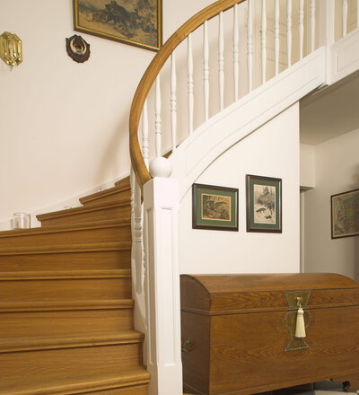 Geschlossene Wangentreppe; Holzart Eiche; Handlauf und Pfosten Holzart Whitewood weiß endlackiert, Handlauf und Wangenkrümmling im Wendel