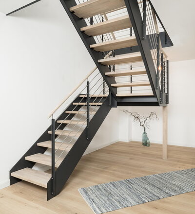 Halb gewendelte HPL-Treppe mit Podest und Milano Geländer 1, Stufen und Handlauf in der Holzart Eiche mosaik weiß geölt mit TBV Echtholz-Öl Cotton White