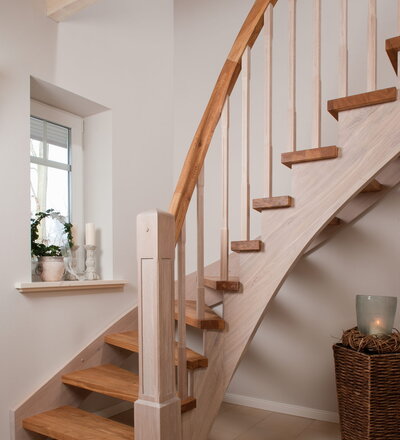 Wangentreppe einseitig aufgesattelt; Holzart Eiche astig; Stufen und Handlauf geölt; Wangen, Stäbe und Pfosten weiß transparent gewachst.