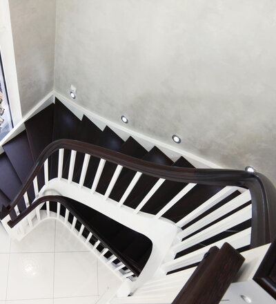 Beidseitig eingestemmte, offene Wangentreppe; Stufen und Handlauf Holzart Buche gebeizt auf Wenge; Wange, Stäbe und Pfosten Holzart Whitewood weiß endlackiert; Handlauf- und Wangenkrümmling