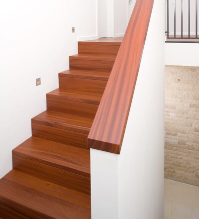 Betontreppenbelegung, bei den Tritt- und Setzstufen ist die Vorderkante bündig mit der Setztufe gearbeitet, dazu eine passende Mauerabdeckung; Holzart Doussie