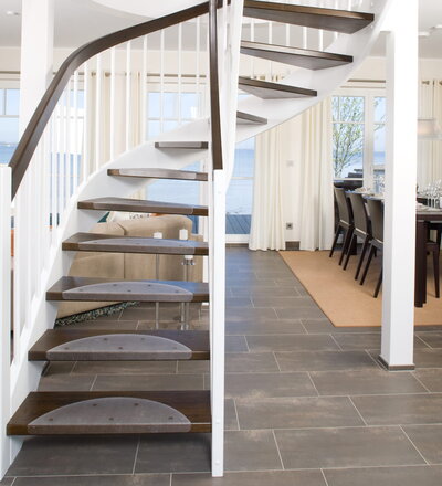 Halb gewendelte Bogentreppe mit Wangen und Stäben in der Holzart Whitewood weiß endlackiert. Stufen und Handlauf in der Holzart Buche auf Wenge gebeizt.