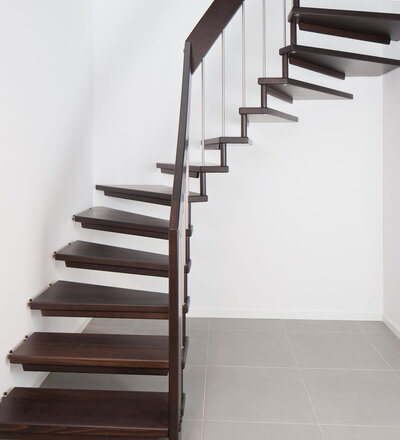 <p>1/2 gewendelte freitragende Treppe, wandseitig gummigelagert; Holzart Buche auf Wenge gebeizt.</p>