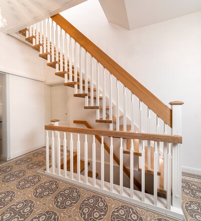 Gerade, freitragende Treppe mit Wandwange, Stufen und Handlauf in der Holzart Eiche farblos geölt.