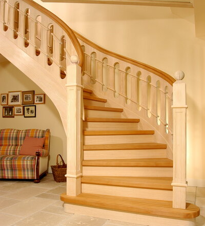 Geschlossene Wangentreppe, aufwändig profilierte Geländerfüllung; Holzart Buche/Carolina Pine