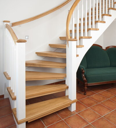 1/4 gewendelte, freiseitig aufgesattelt und wandseitig eingestemmte offene Wangentreppe, Stufen und Handlauf Holzart Eiche, Stäbe, Pfosten und Wange Whitewood weiß endlackiert.