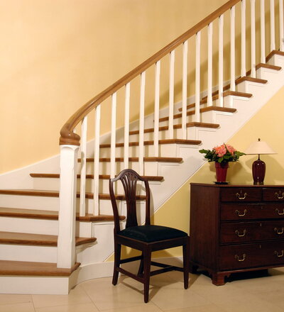 Steigegeländer und Trittstufenbelegung einer Betontreppenanlage; Handlauf am Antrittspfosten als Schnecke auslaufend; Holzart Eiche