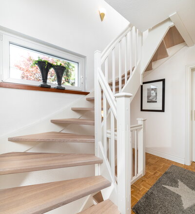 Beidseitig eingestemmte Wangentreppe, Stufen und Handlauf in der Holzart Eiche weiß geölt.