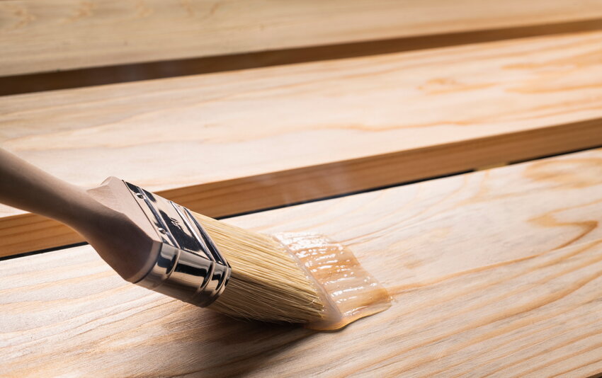 TBV-Echtholz-Öl wird mit einem Pinsel auf Holz aufgetragen.