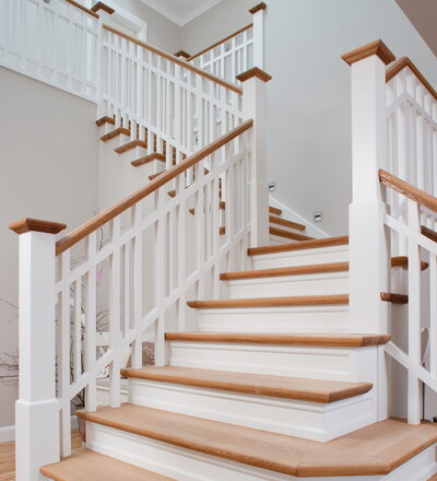 Steigegeländer und Stufenbelegung einer Betontreppe; Setzstufen mit aufgesetzten Profilleisten, aufwendig nach Kundenwunsch gestaltete Geländerkonstruktion