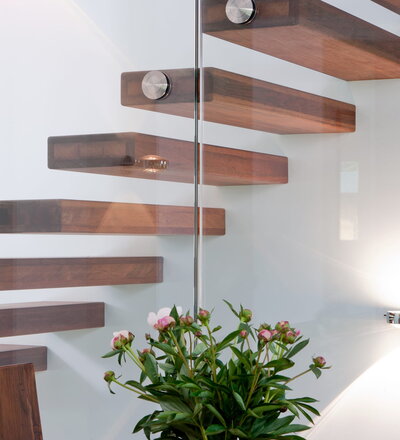 Kragarmtreppe mit schwebender Stufenoptik und Glasgeländer; Holzart Merbau