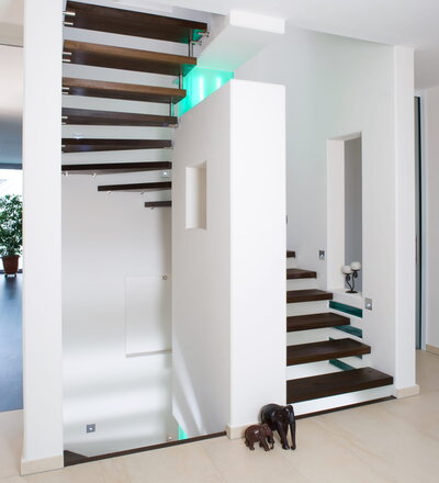 Trittstufen auf speziellen gummigelagerten Edelstahlbeschlägen, beidseitig in Massivwänden befestigt; Holzart Eiche geräuchert